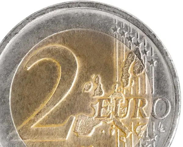 Gros plan d'une pièce de 2 euros commémorative. Le chiffre "2" est bien visible, ainsi que le mot "EURO" et une carte de l'Europe.