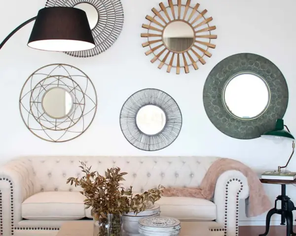 Salón moderno con sofá blanco, lámpara de pie y varios espejos decorativos que siguen principios de feng shui para atraer energía positiva.