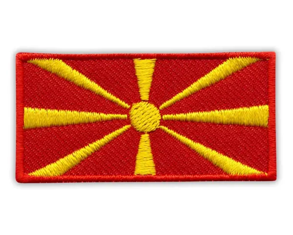 Naszywka z flagą Macedonii. Czerwone tło z żółtym słońcem i promieniami.