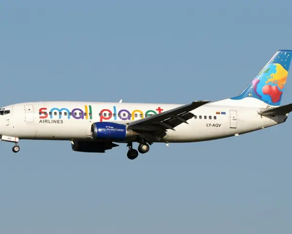 Samolot linii Small Planet Airlines z kolorowym motywem globu na ogonie.