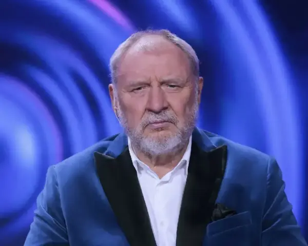 Andrzej Grabowski żyje i wygląda na zmęczonego, siedząc w niebieskiej marynarce na tle niebieskich świateł.
