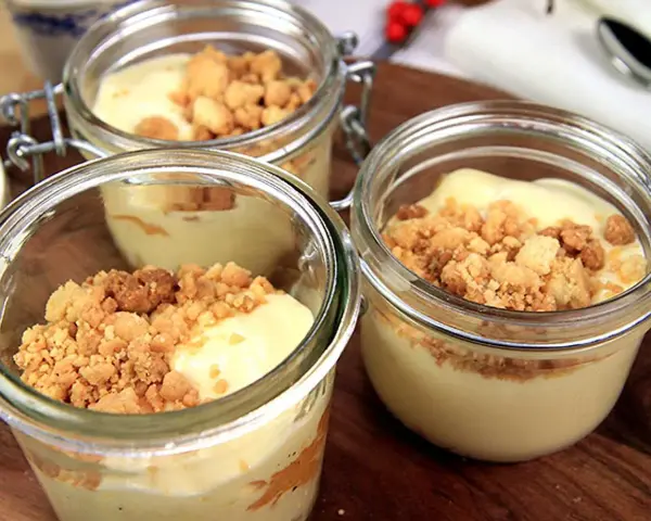 Tre små glasburkar med len vit chokladmousse toppad med smulig crumble. Perfekt för en söt stund.