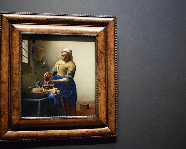 Une femme verse du lait dans un bol, une scène de la vie quotidienne magnifiquement rendue par la technique de peindre à l'huile.