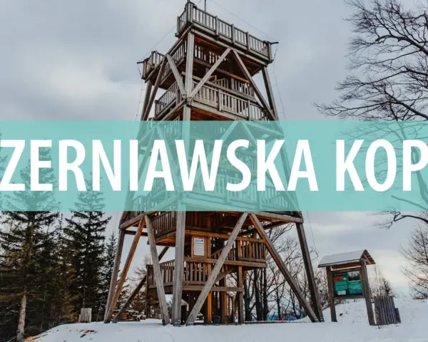 Drewniana wieża widokowa na szczycie Czerniawska Kopa, otoczona zimowym lasem.