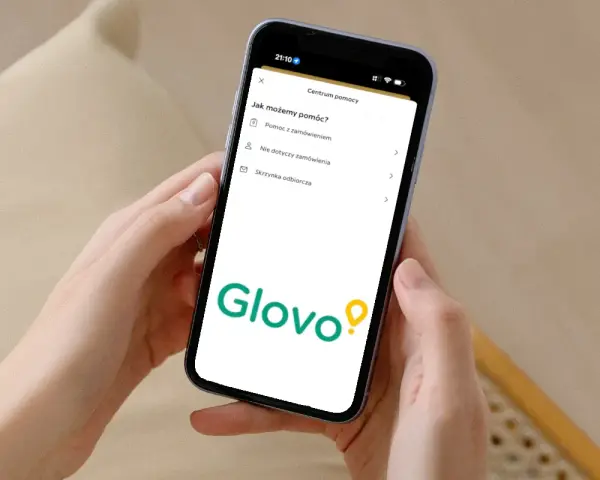 Na ekranie telefonu widoczny jest interfejs aplikacji Glovo z sekcją "Centrum pomocy". Tutaj znajdziesz informacje, jak uzyskać pomoc z zamówieniem, a także inne opcje.