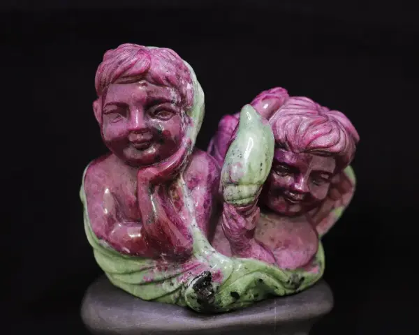 Due angioletti scolpiti in zoisite, con le loro proprietà che sembrano brillare.