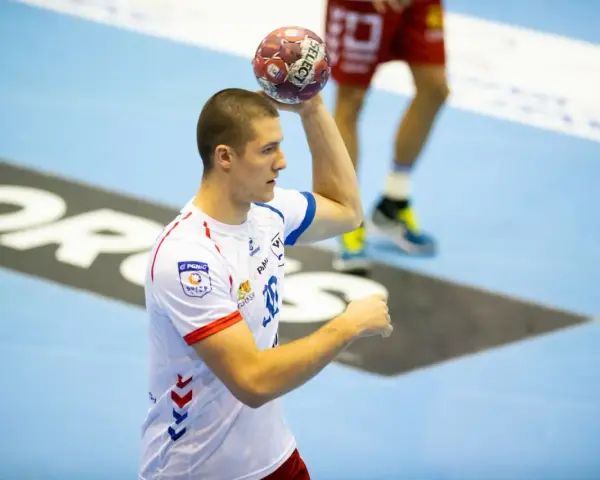 Wiktor Tomczak, zawodnik piłki ręcznej, przygotowuje się do rzutu.