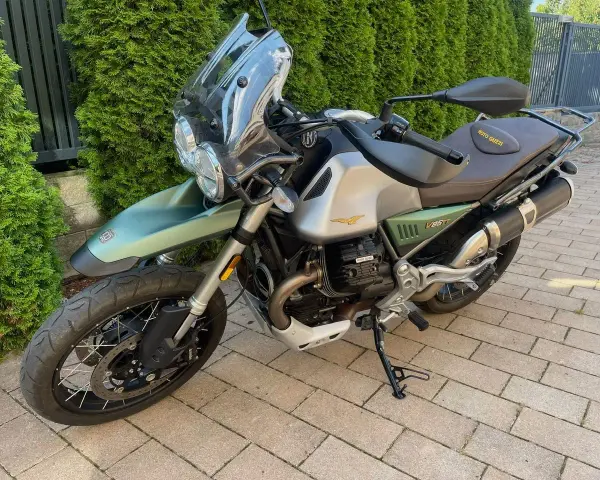 Zielony motocykl Moto Guzzi V85TT z silnikiem V, gotowy na przygodę.