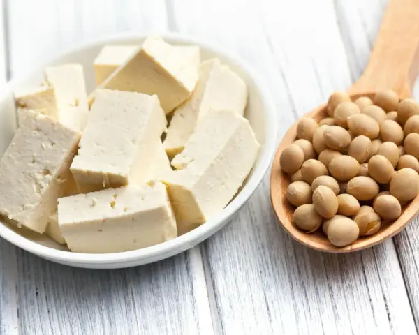 Kostki tofu w misce i łyżka pełna soi. Tofu co to? To produkt z soi, idealny do wegańskich dań.