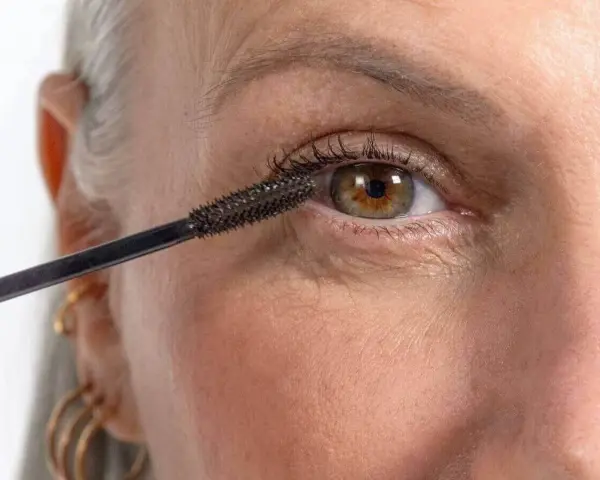 Application de mascara sur des cils. On se demande combien de temps dure un mascara avant de devoir le remplacer.