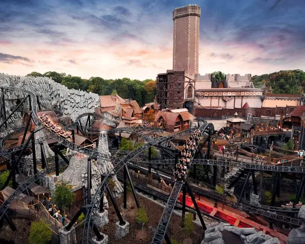 Achtung, **Phantasialand Geburtstagskinder**! Die Achterbahn rast durch eine mittelalterliche Kulisse mit Burg und Felsen.