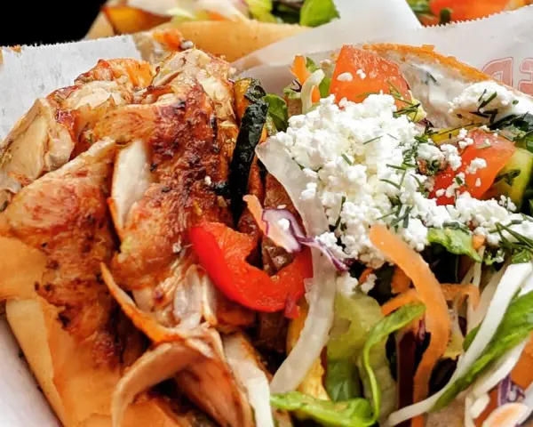 Kebab z kurczakiem w bułce z warzywami i serem feta.