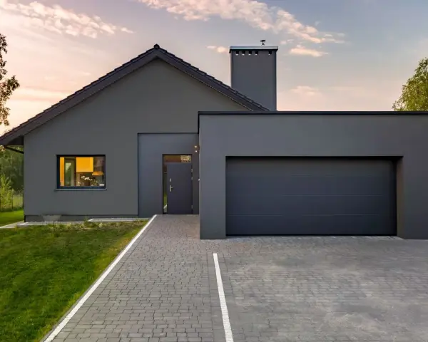 Casa moderna con tetto spiovente e garage, perfetta per un progetto di pitturare esterno casa. Il grigio antracite dona un aspetto elegante.