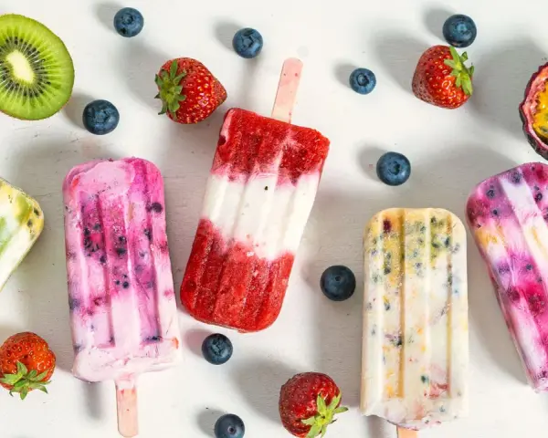 Fruchteis am Stiel mit Beeren, Kiwi und Maracuja. Welches Eis hat am wenigsten Zucker? Die bunten Eis am Stiel sehen lecker aus.
