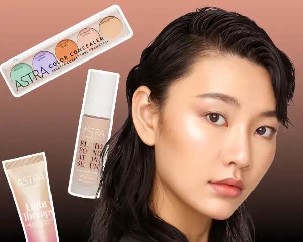 Une femme au teint lumineux, prête pour le maquillage, avec une palette de correcteurs, un fond de teint sérum et un highlighter Astra.
