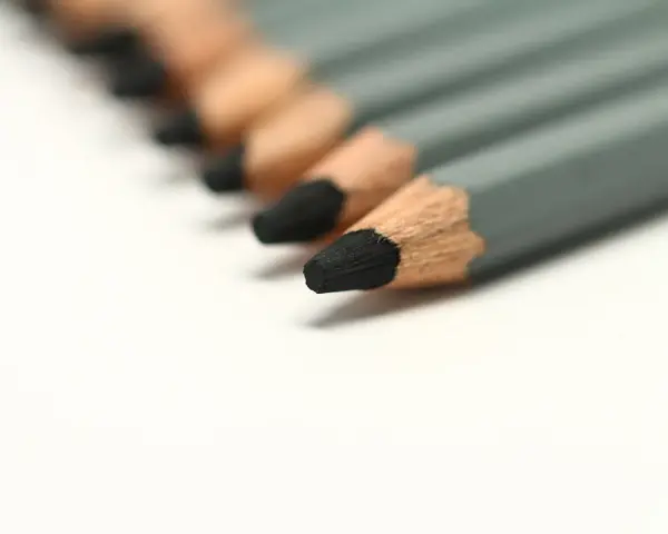 Una fila de lápices duros de grafito gris, listos para dibujar o escribir.