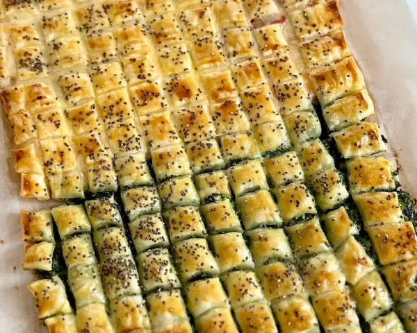 Stuzzichini sfiziosi con pasta sfoglia veloce, ripieni di spinaci e cosparsi di semi di chia. Perfetti per un aperitivo o una merenda golosa.