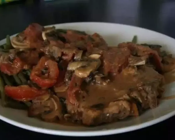 Un savoureux sauté de veau tomates champignons, servi avec des haricots verts. Un plat réconfortant et plein de saveurs.