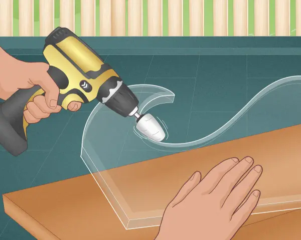 Using a rotary tool to carefully shape a piece of plastic, demonstrating how to cut plastic glass for a custom project.