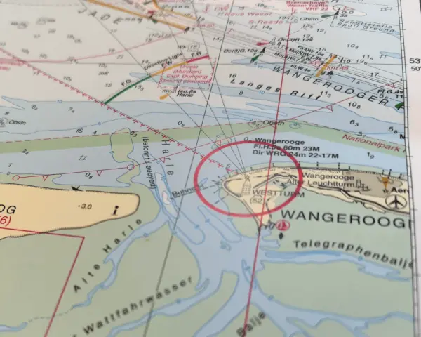 Seekarten-Details zeigen Wangerooge mit Leuchtturm und Schiffshorn-Signalen.