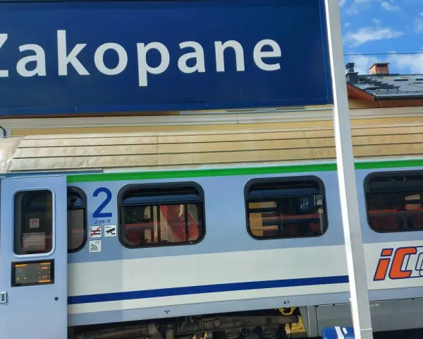 Niebieski znak "Zakopane" nad pociągiem PKP Intercity z numerem wagonu 2.