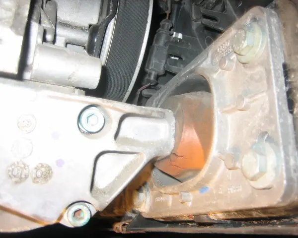 Zużyta poduszka silnika w Audi p1577. Widoczne pęknięcia gumy i metalowe elementy mocujące.