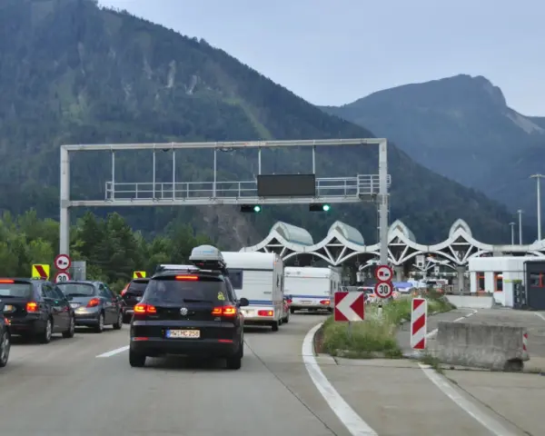 Korki na autostradzie przed punktem poboru opłat z widokiem na góry.