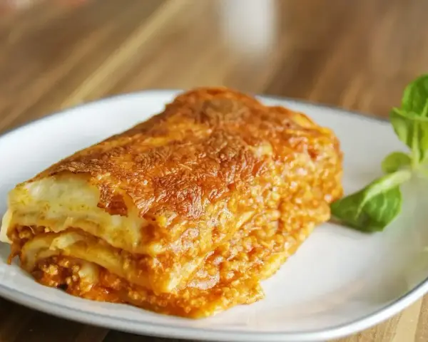 Pyszna, złocista lasagne na talerzu. Idealna na obiad, gdy masz ochotę na coś sycącego. Ten przepis na lasagne na pewno Ci się spodoba!