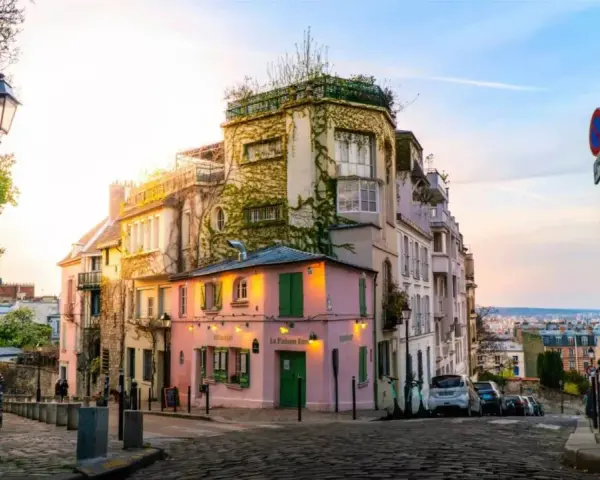 Charmante Gasse in Montmartre, Paris. Ein rosa Restaurant mit grünen Fensterläden. Tolle Paris Tipps für deinen nächsten Besuch!