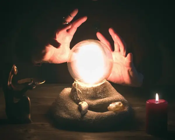 Dłonie otaczają lśniącą kulę, która zdaje się zawierać przyszłość. To magiczna wróżba z kuli, gdzie tajemnice czekają na odkrycie.