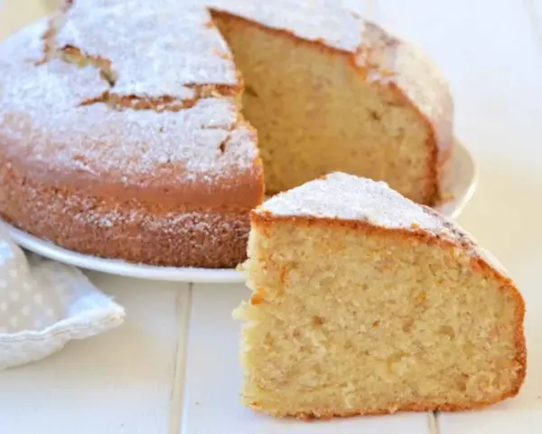 Una soffice torta di banane, spolverata di zucchero a velo, con una fetta tagliata per gustarla.