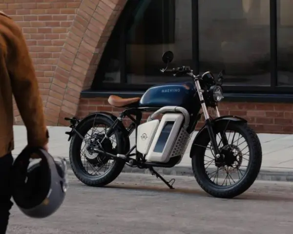 Eleganckie motocykle retro w miejskiej scenerii. Mężczyzna w brązowej kurtce trzyma kask, gotowy do jazdy.