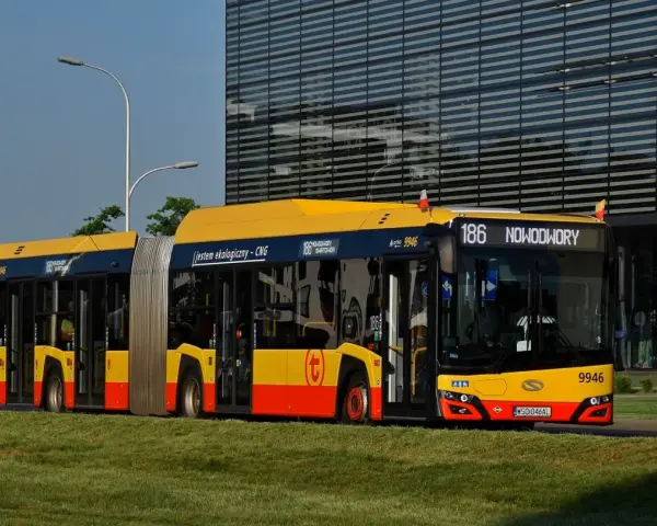 Długi, przegubowy autobus 186 z napisem "jestem ekologiczny - CNG" jedzie w kierunku Nowodworów.
