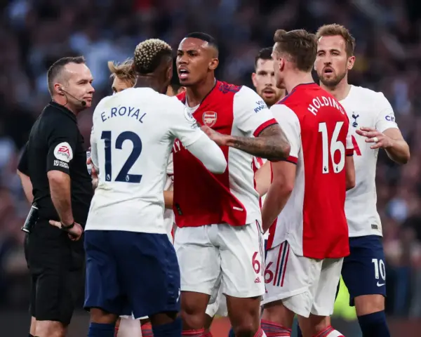 Piłkarze Arsenalu i Tottenhamu w gorącej dyskusji z sędzią. To właśnie co to są derby w piłce nożnej – mecze pełne emocji i napięcia.