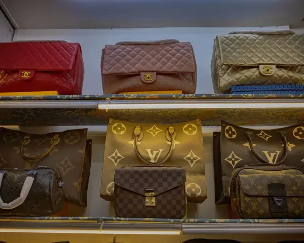Borse Louis Vuitton fuori produzione, tra cui modelli classici e versioni con monogrammi iconici, esposte su scaffali illuminati.