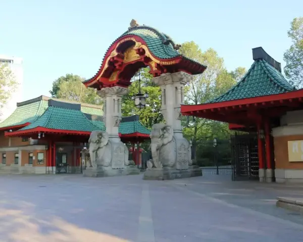 Eingang zum zoologischer garten mit asiatischer Architektur, Elefantenstatuen und grünen Dächern.