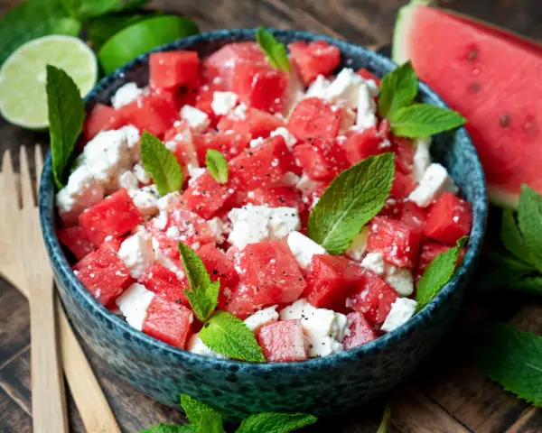 Erfrischender Wassermelone Feta Salat mit Minze und Limette, garniert mit schwarzem Pfeffer. Perfekt für heiße Tage.