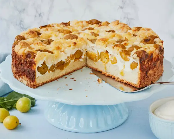 Saftiger Mirabellenkuchen mit Streuseln und cremiger Füllung auf einer hellblauen Tortenplatte.