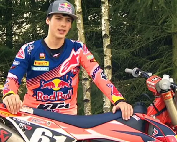 Jorge Prado, piloto de motocross, posa con su moto KTM en un bosque.