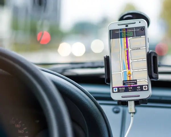 Uchwyt na telefon w samochodzie z nawigacją. Pokazuje trasę w Amsterdamie, jak zamontować uchwyt na telefon w samochodzie.