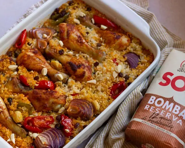Delicioso arroz al horno con pollo, pimientos, cebolla y pasas. Un plato reconfortante y lleno de sabor.