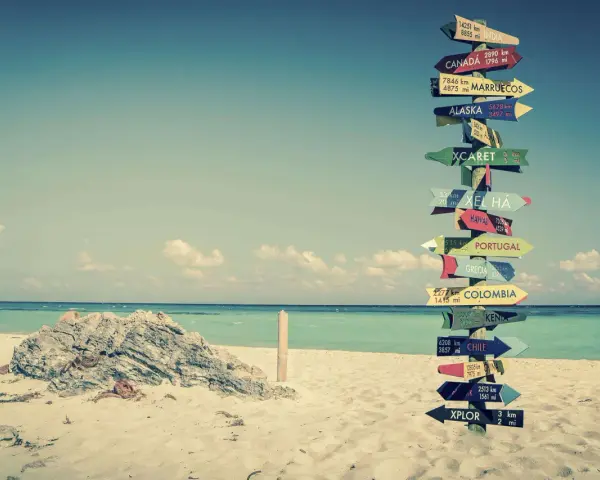 Strand mit Schildern zu fernen Zielen. Ein Traum für ein **auslandsjahr kostenlos**?