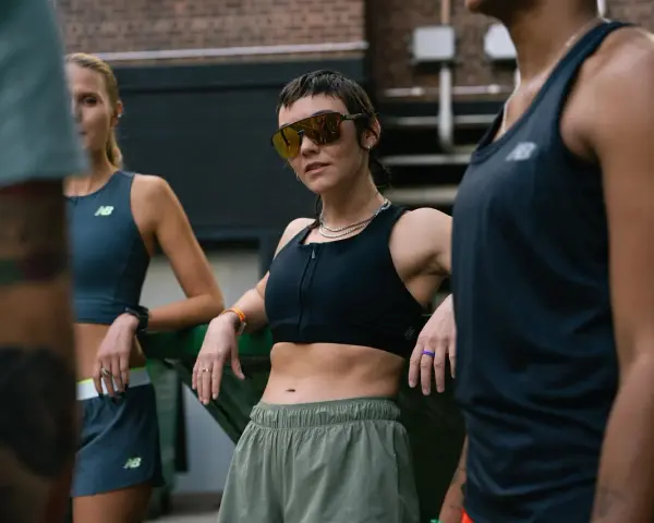 Trzy kobiety w strojach sportowych, zastanawiające się, czy chodzenie odchudza. Jedna w okularach przeciwsłonecznych.
