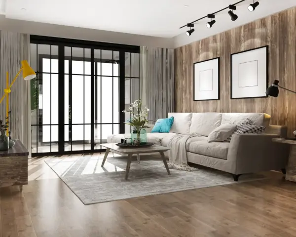 Soggiorno accogliente con divano beige, tavolino in legno e lampada gialla. Un esempio di come arredare casa con poco, creando stile e comfort.