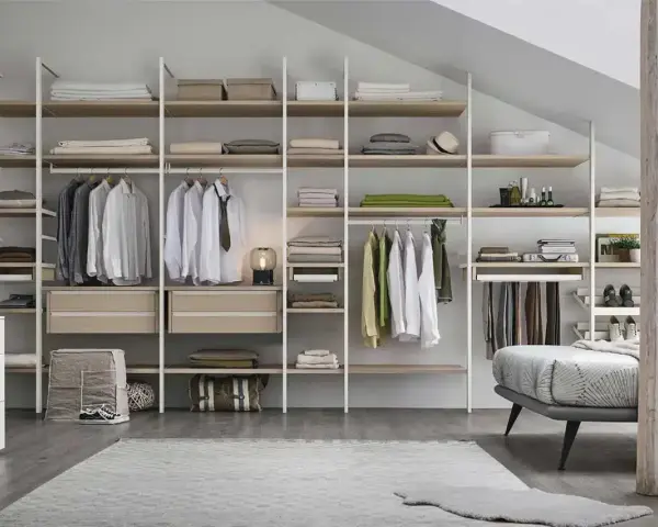 Un'idea per progettare cabina armadio: scaffali a vista con abiti appesi, cassetti e accessori.