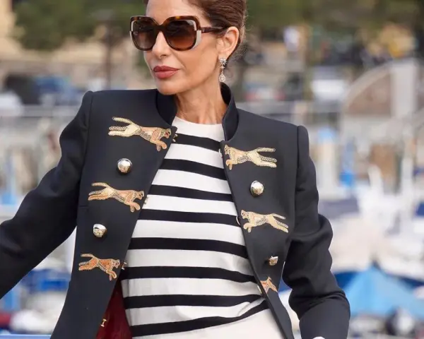 Elegancka kobieta w okularach przeciwsłonecznych i marynarce z motywem gepardów, w stylu francuskim.