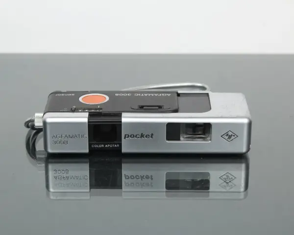 Srebrny aparat Agfamatic 3008 z napisem "pocket" i logo Agfa. Idealny do uchwycenia wspomnień.