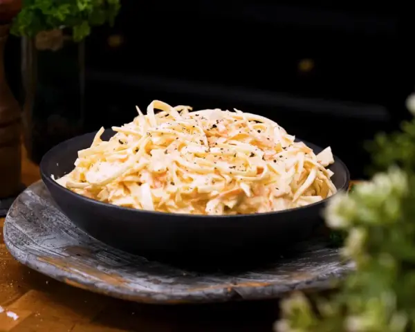 En skål med krämig, godaste coleslaw, toppad med peppar. Perfekt tillbehör!
