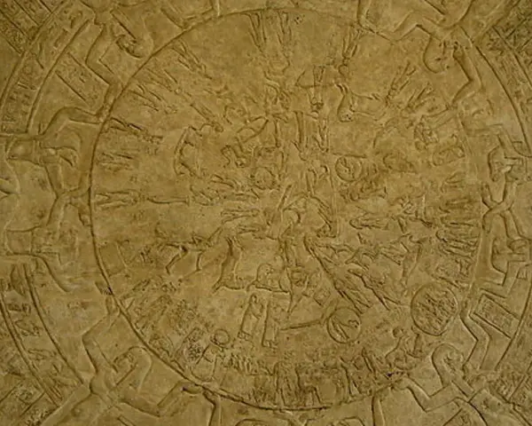 Bas-relief circulaire du zodiaque de Dendérah, représentant des figures mythologiques et des constellations dans un style égyptien ancien.