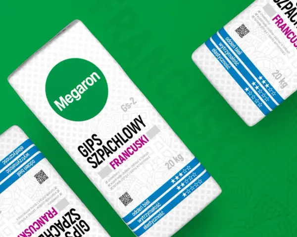Trzy worki gipsu szpachlowego francuskiego Megaron, każdy po 20 kg, z zielonym logo i niebieskimi pasami.